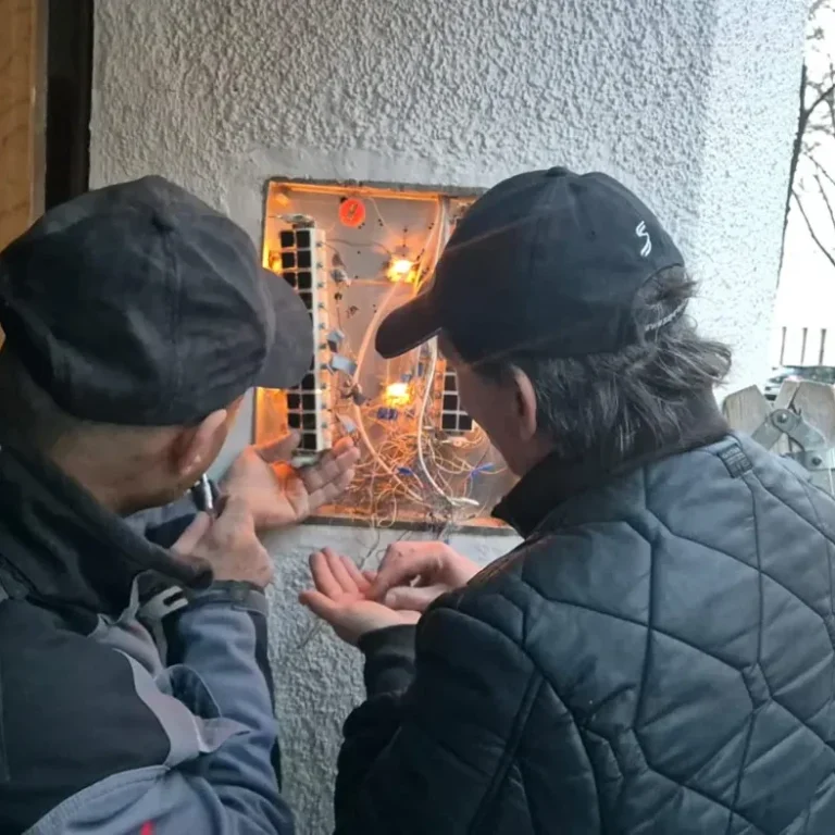 Elektriker bei der Reparatur einer Gegensprechanlage und Sprechanlage in einem Wohnhaus in Wien
